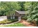 Charming home featuring stone accents and gray trim, surrounded by lush landscaping and mature trees at 2717 Hearthstone Cir, Marietta, GA 30062