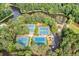 Aerial view of multiple blue tennis courts surrounded by lush trees near a lake at 2717 Hearthstone Cir, Marietta, GA 30062