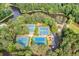 Aerial view featuring multiple tennis courts surrounded by mature trees and a tranquil pond at 2717 Hearthstone Cir, Marietta, GA 30062