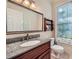 Bathroom features a granite countertop, wood vanity, and a large framed mirror at 7155 Roswell Rd # 58, Atlanta, GA 30328