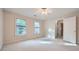 Bright bedroom with two windows, neutral walls, carpet, and ceiling fan at 7155 Roswell Rd # 58, Atlanta, GA 30328