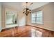 This dining room features hardwood floors, elegant trim and a chandelier with views of the side yard at 7155 Roswell Rd # 58, Atlanta, GA 30328