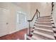 Bright foyer featuring hardwood floors, a staircase, and a front door with decorative glass at 7155 Roswell Rd # 58, Atlanta, GA 30328