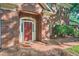 Close up of brick home showcasing an arched portico and inviting red front door at 7155 Roswell Rd # 58, Atlanta, GA 30328