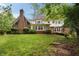 Expansive backyard featuring lush green grass, mature trees, and a charming brick and siding home at 1595 Bakers Glen Dr, Atlanta, GA 30350