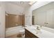 Bathroom features a tub with tile surround, a sink with vanity, and neutral tile flooring at 1595 Bakers Glen Dr, Atlanta, GA 30350