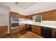 Well-lit kitchen with wood cabinets, stainless steel oven, and black dishwasher at 1595 Bakers Glen Dr, Atlanta, GA 30350