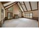 Bright and spacious living room with high ceilings, wood beams, large windows, and a cozy fireplace at 1595 Bakers Glen Dr, Atlanta, GA 30350