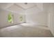 Bright main bedroom with tray ceiling, plush carpet, and views of the surrounding greenery at 1595 Bakers Glen Dr, Atlanta, GA 30350