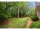 Lush yard with brick path leading to a serene wooded area, complemented by well-maintained landscaping at 1595 Bakers Glen Dr, Atlanta, GA 30350