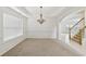 A bright living room features carpet, wainscoting detail, a chandelier, and a large window at 230 Collins View Ct, Lawrenceville, GA 30043