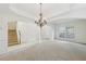Open-concept living space with elegant chandelier, carpet flooring, and abundant natural light at 230 Collins View Ct, Lawrenceville, GA 30043
