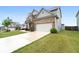 A side view of a brick and gray home with a long driveway leading to a two-car garage at 2537 Sori Dr, Buford, GA 30519