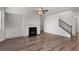 Open-concept living room with wood flooring, fireplace, and staircase with white walls at 2537 Sori Dr, Buford, GA 30519