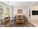 Cozy living room featuring a gray sofa with bright pillows, an elegant rug, and custom built-in shelving at 525 Arbor Creek Ct, Roswell, GA 30076