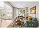 Bright living room with a gray sofa, area rug, bay window, and entry with a double door at 525 Arbor Creek Ct, Roswell, GA 30076