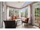 Cozy sunroom with lots of natural light, comfortable seating, and views of the surrounding landscape at 525 Arbor Creek Ct, Roswell, GA 30076