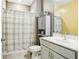 Neat bathroom featuring a shower with patterned curtains, a vanity with a sink, and a storage cabinet at 160 Amherst Way, Fayetteville, GA 30215