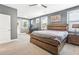 Modern bedroom featuring a wooden platform bed, neutral carpet, and desk area, flooded with natural light at 160 Amherst Way, Fayetteville, GA 30215