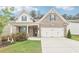 Charming brick home with a two-car garage and beautifully landscaped front yard at 160 Amherst Way, Fayetteville, GA 30215