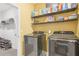 Functional laundry room with modern washer and dryer units and open shelving for storage at 160 Amherst Way, Fayetteville, GA 30215