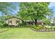 Charming home featuring a lush front yard with manicured landscaping and mature trees, creating inviting curb appeal at 733 Huntington Se Pl, Marietta, GA 30067