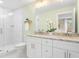 Bright bathroom featuring double vanity with granite counters and white cabinets, and glass enclosed shower at 1583 Braeburn Se Dr, Atlanta, GA 30316