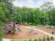 Outdoor playground with play structures, slides, and swings surrounded by green trees at 1583 Braeburn Se Dr, Atlanta, GA 30316