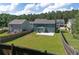 Aerial view of fenced backyard, green lawn, and patio with mature trees at 211 Augusta Woods Dr, Villa Rica, GA 30180
