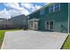 Spacious concrete patio in backyard with green siding, grill, and fenced in yard at 211 Augusta Woods Dr, Villa Rica, GA 30180