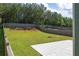A fully fenced in backyard with lush green grass and mature trees at 211 Augusta Woods Dr, Villa Rica, GA 30180
