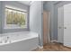 Bathroom with tub, shower, a window, neutral walls, and a linen closet at 211 Augusta Woods Dr, Villa Rica, GA 30180