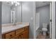 Bathroom with a sink, wooden vanity, and a mirror, with a view of the toilet and shower at 211 Augusta Woods Dr, Villa Rica, GA 30180