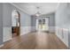 Dining area showcasing hardwood floors, wainscoting, modern lighting, and natural light from the window at 211 Augusta Woods Dr, Villa Rica, GA 30180