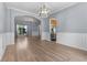 Elegant dining room featuring hardwood floors, wainscoting detail, modern lighting, and backyard view at 211 Augusta Woods Dr, Villa Rica, GA 30180