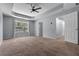 Large main bedroom with a tray ceiling, carpet, and a window with views of the backyard at 211 Augusta Woods Dr, Villa Rica, GA 30180