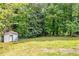 Spacious backyard with mature trees and a storage shed on a well-maintained lawn at 2678 Rainbow Forest Dr, Decatur, GA 30034