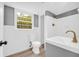Modern bathroom with tiled shower and sink, window, new toilet, and grey and white decor at 2678 Rainbow Forest Dr, Decatur, GA 30034