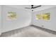 A bright bedroom featuring two windows with views of the surrounding trees and a modern ceiling fan at 2678 Rainbow Forest Dr, Decatur, GA 30034