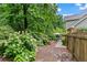 Secluded backyard with a dining set, a grill, lush landscaping, and ambient string lights at 4792 Fairville Ct, Marietta, GA 30062