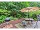 Serene backyard featuring an umbrella-covered dining set, a grill, and ambient string lights at 4792 Fairville Ct, Marietta, GA 30062