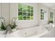 Bathroom featuring tub with marble surround and tranquil views of the wooded property at 4792 Fairville Ct, Marietta, GA 30062
