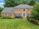 Charming brick home with a manicured lawn, updated windows and blue door, set amidst lush landscaping at 4792 Fairville Ct, Marietta, GA 30062