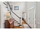 Bright foyer with a staircase featuring elegant black and white trim, hardwood floors, and an antique desk at 4792 Fairville Ct, Marietta, GA 30062