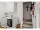 Bright laundry room with modern washer and dryer, white cabinets and direct access to stairs at 4792 Fairville Ct, Marietta, GA 30062