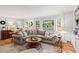 Bright living room with large windows, gray sectional sofa, wood floors and modern decor at 4792 Fairville Ct, Marietta, GA 30062