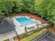 Community pool surrounded by lounge chairs and umbrellas and lush trees provides a relaxing outdoor space at 4792 Fairville Ct, Marietta, GA 30062