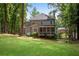 Secluded backyard showcasing a well-maintained lawn, mature trees, and a charming exterior view of the home at 5301 Regency Lake Ct, Sugar Hill, GA 30518