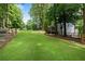 Expansive backyard featuring lush lawn, mature trees, and a charming fence, creating a private oasis at 5301 Regency Lake Ct, Sugar Hill, GA 30518