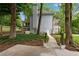 Backyard view highlighting a stone walkway, lush landscaping, and access to the home's exterior at 5301 Regency Lake Ct, Sugar Hill, GA 30518